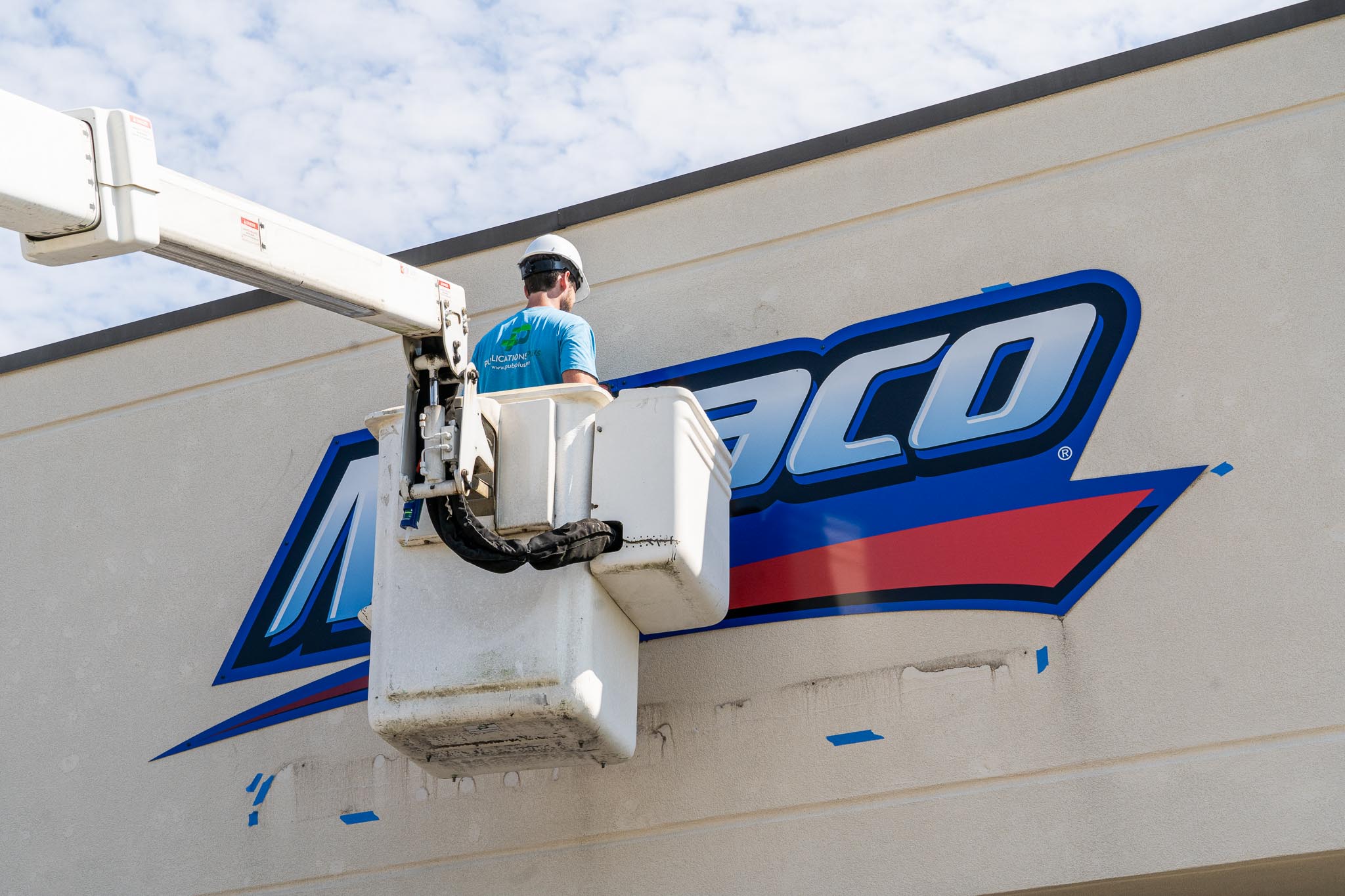 Man in bucket truck installing an outdoor sign