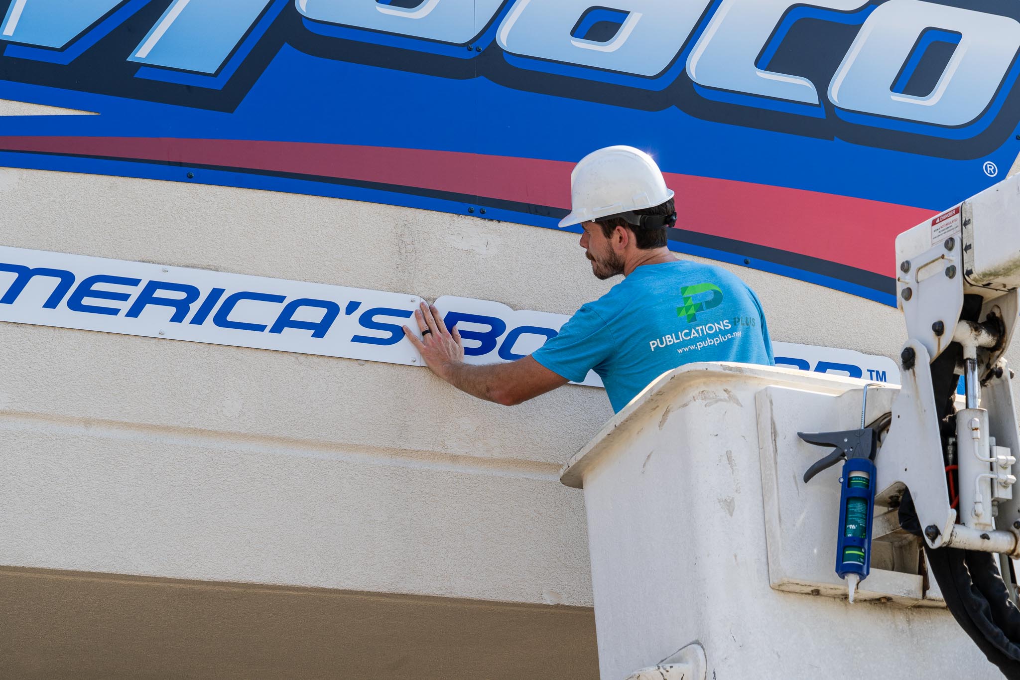 Man in bucket truck installing an outdoor sign