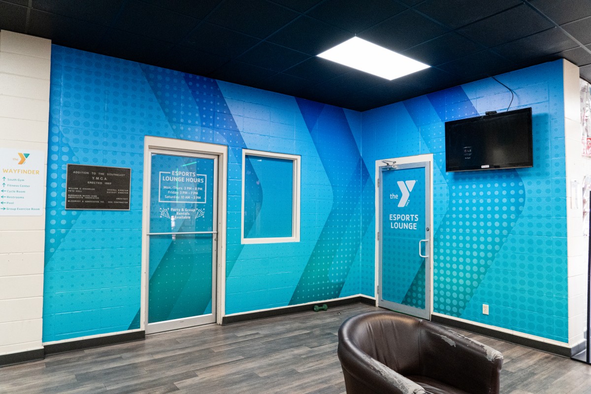 A vibrant blue and green wall wrap decal for the YMCA Midtown Esports lounge