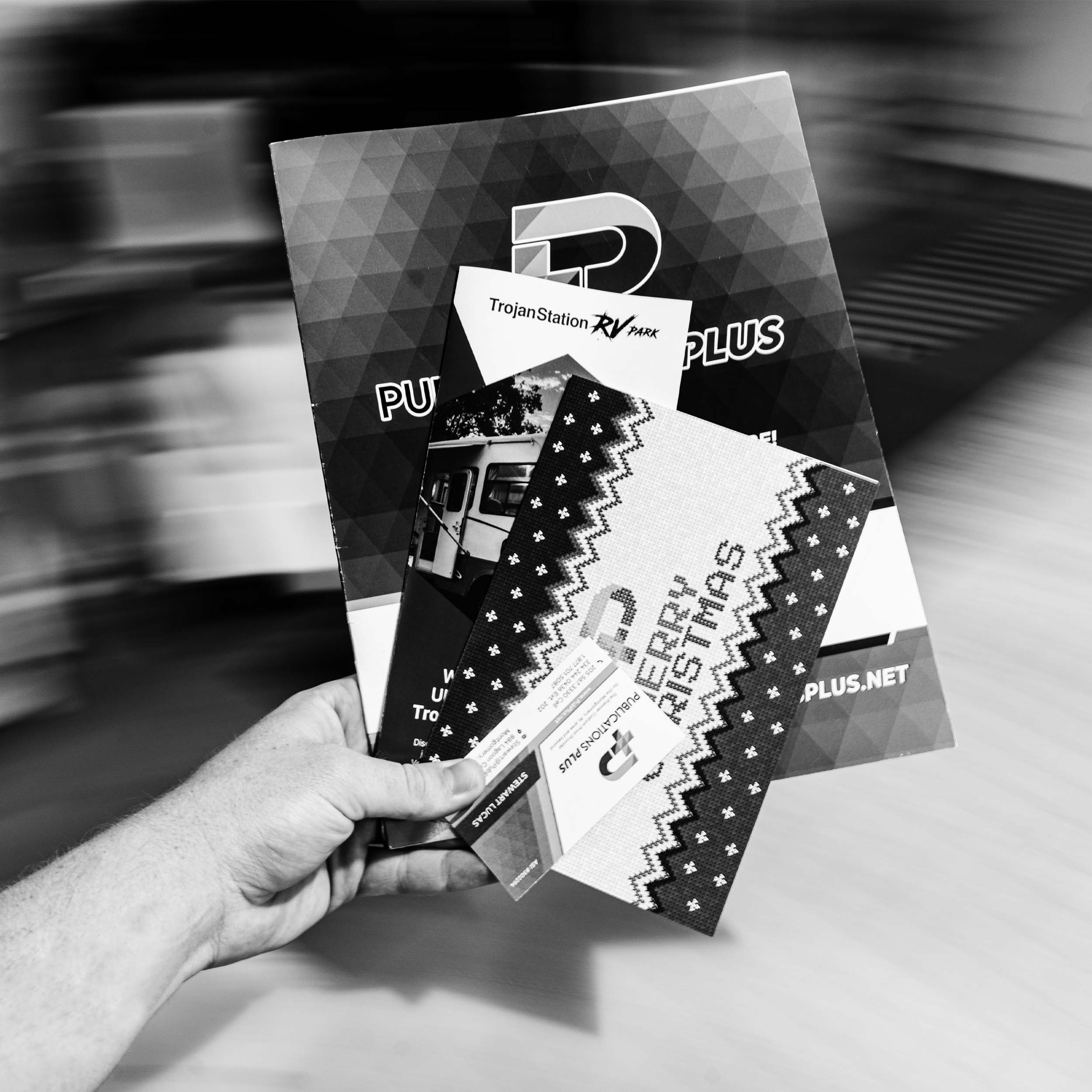 A hand holding multiple printed items