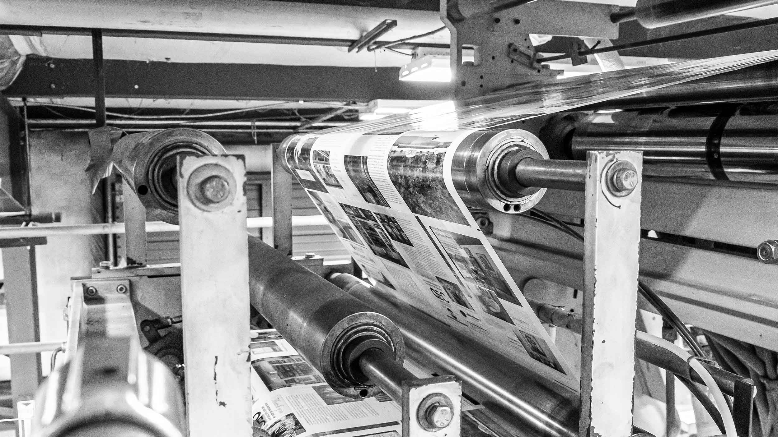 Large printer roller printing pages of magazines
