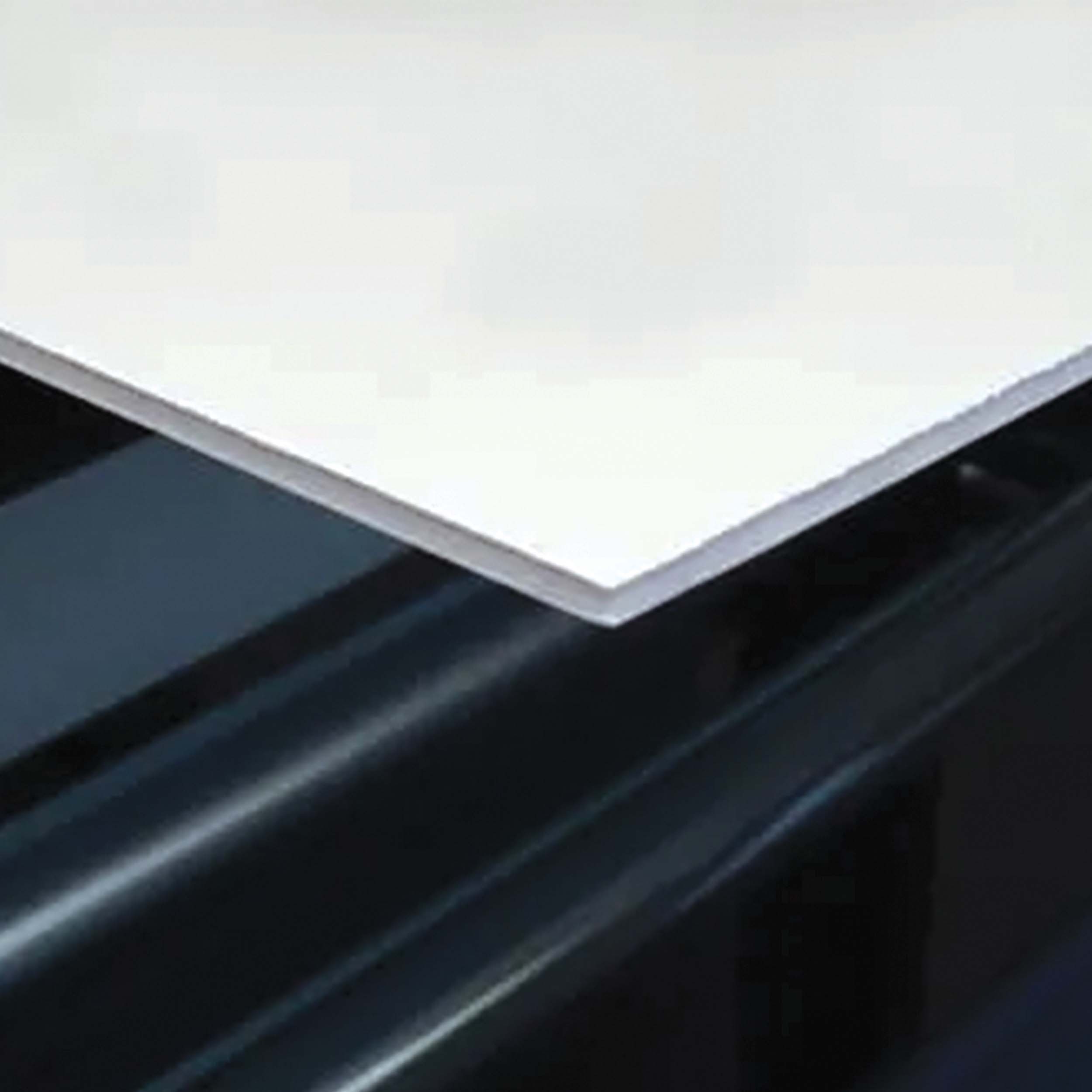 White square edge of foam board laying on black background.