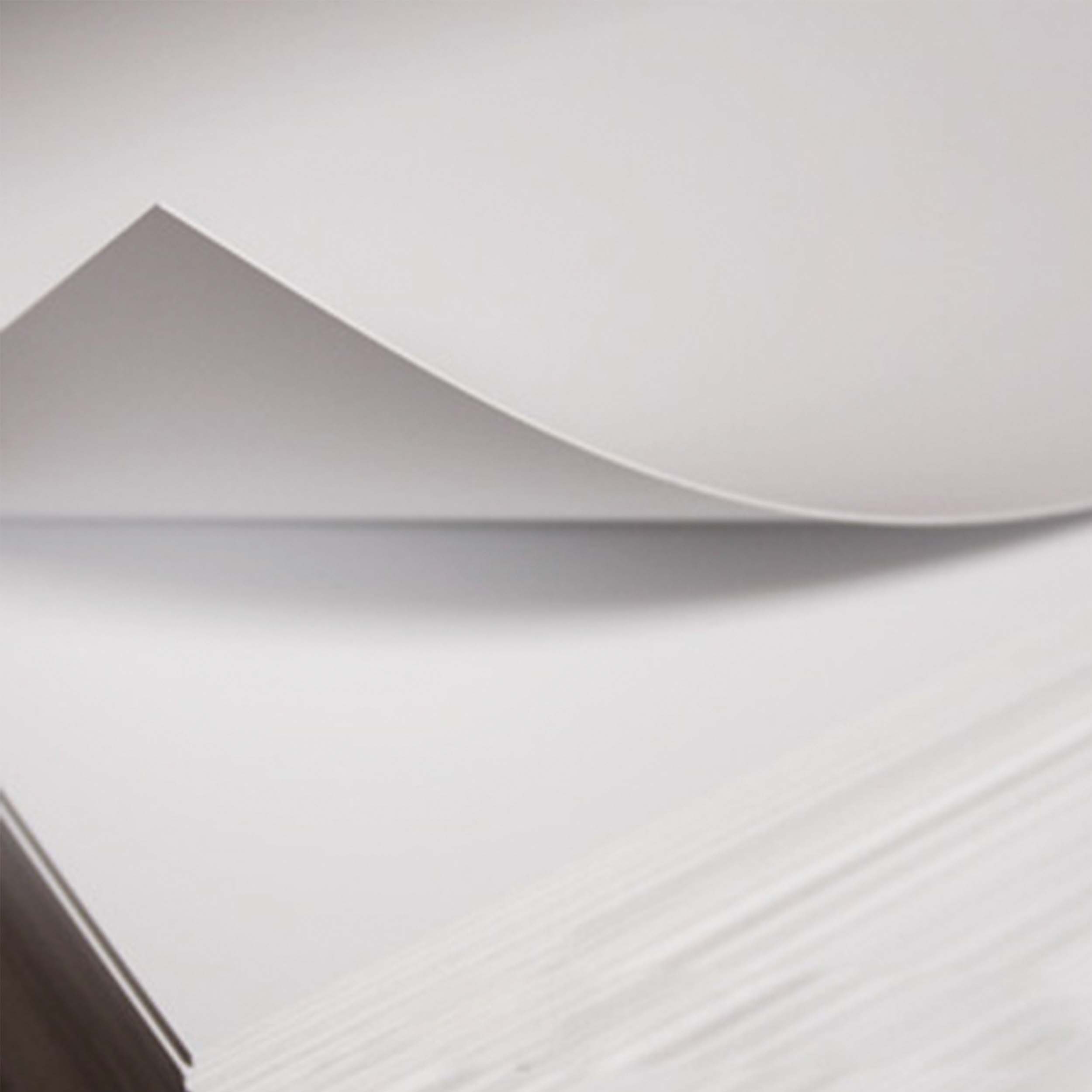 Stack of white styrene sheets with one sheet being lifted up.